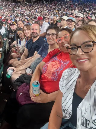 A group of people take a selfie in a crowd.
