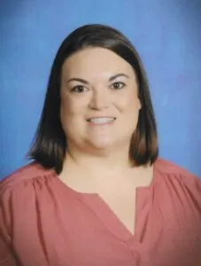 A school portrait of a woman with brown hair wearing a rose-colored shirt