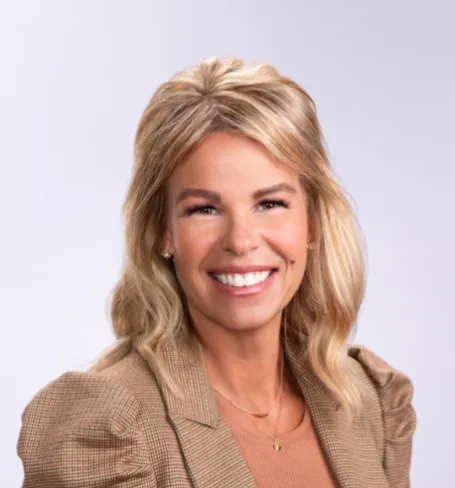 A blonde woman smiles at the camera. 