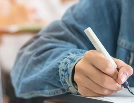 A photo of a person writing at a desk