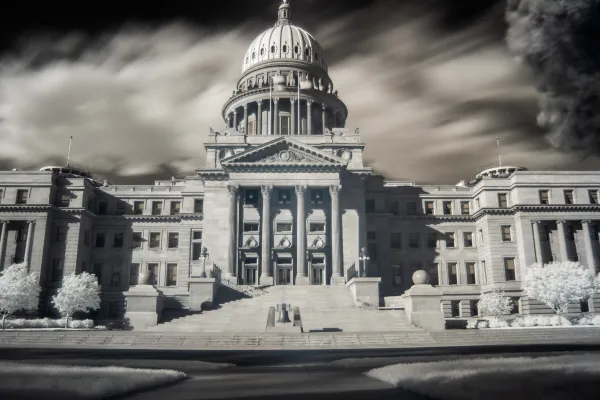 A moody, atmospheric black-and-white photo of the Idaho Statehouse
