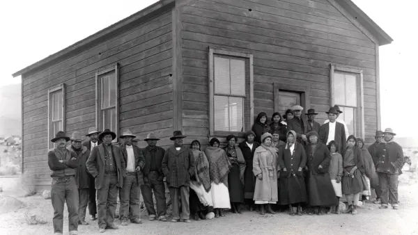 A historic photo of a group of people in front of a building