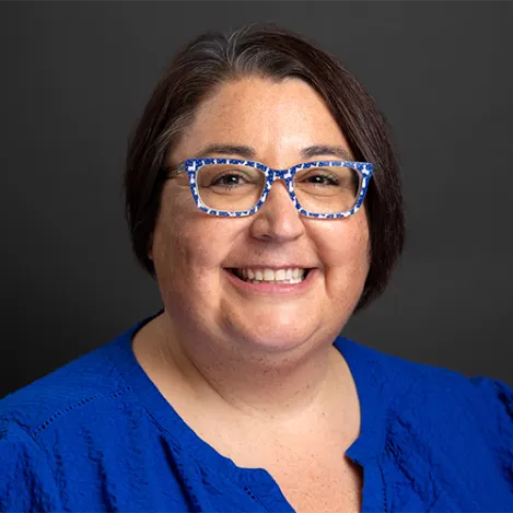 A woman with blue-and-white glasses and a blue shirt