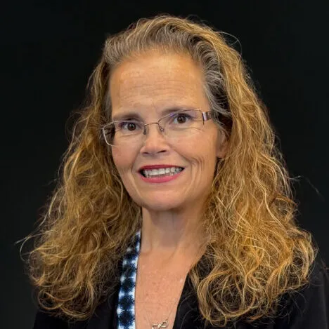 A woman with long blonde hair and glasses