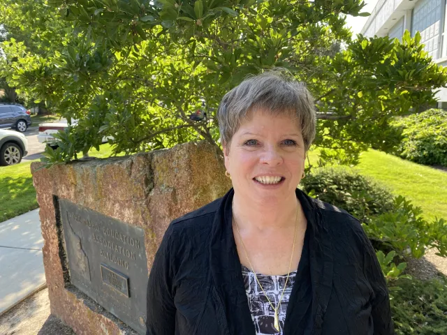 A woman with short gray hair smiles at the camera