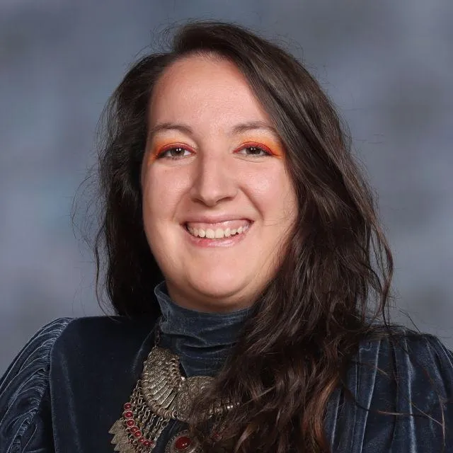 A woman with brown hair smiles at the camera