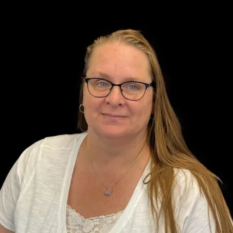 A woman wearing a white top and wearing dark glasses