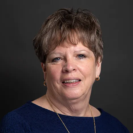 A woman with short hair wearing a blue top