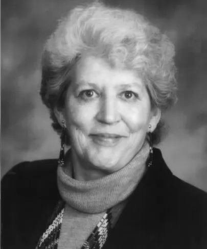 An historic photo of a woman smiling confidently into the camera