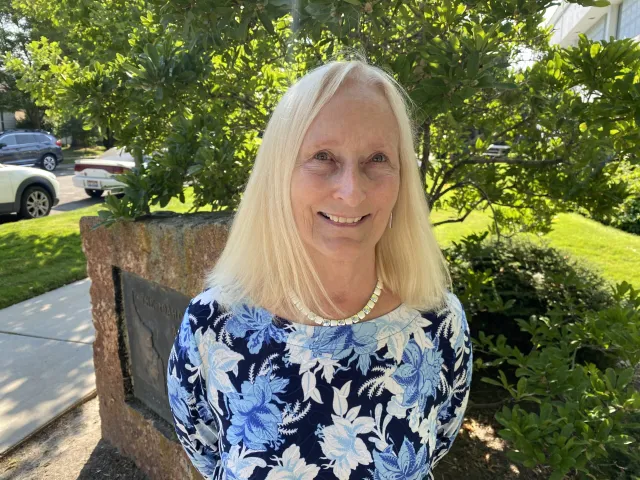 Photo of a woman with long blonde hair smiling at the camera
