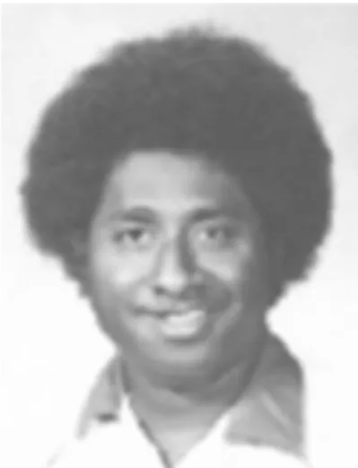 An historic photo of a man with dark hair smiles at the camera