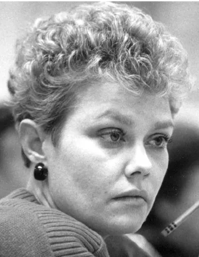 An historic photo of a woman with short hair staring intently