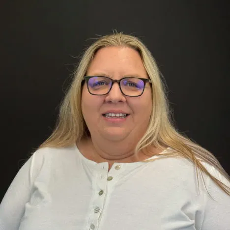 A woman with blonde hair and glasses