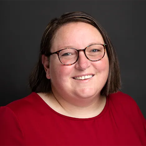 A woman with glasses and wearing a red shirt