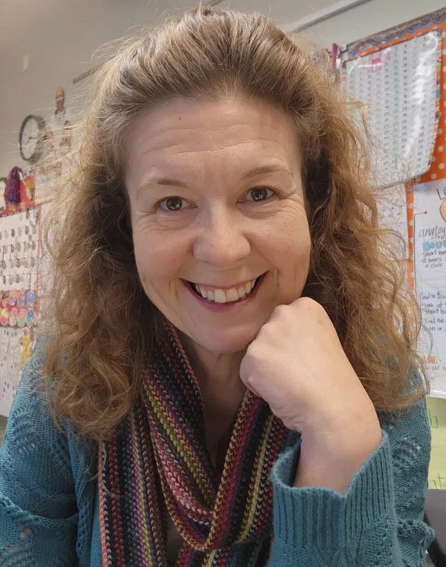 A woman with auburn hair smiles into the camera