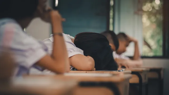 Student lays head down on desk. 